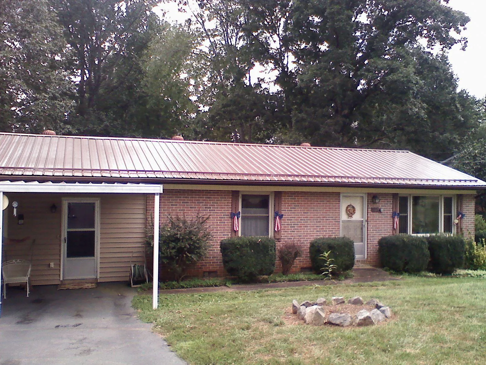 Bronze metal roof and carport on a brick ranch home — Roof Repair work by our crew in Issue